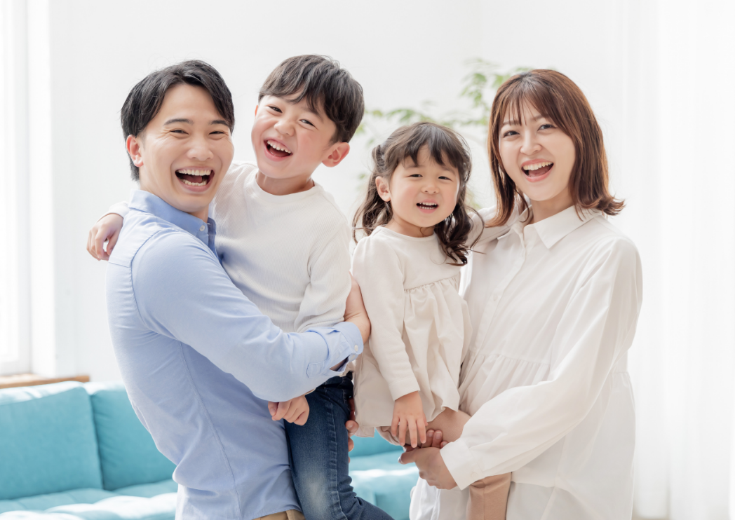 子どもを抱っこした笑顔の夫婦