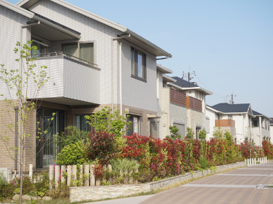 庭でガーデニングをしている2階建ての一軒家